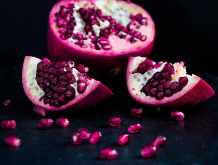 Fresh Pomegranate in black texture backgroundの写真素材