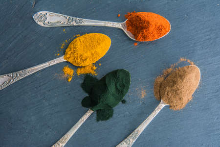 Super powders in spoons - matcha  turmeric  cocoa  spirulinaの写真素材