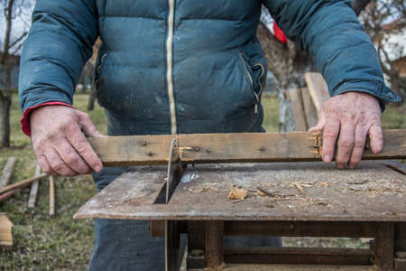 Carpenter's Hands Cutting Wood With Tablesawの写真素材