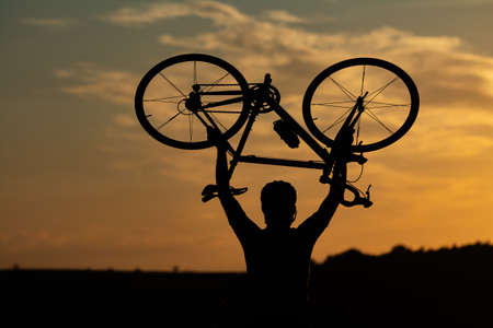Sports and outdoor activities concept.Silhouette of cyclist riding a road bike on open road in...