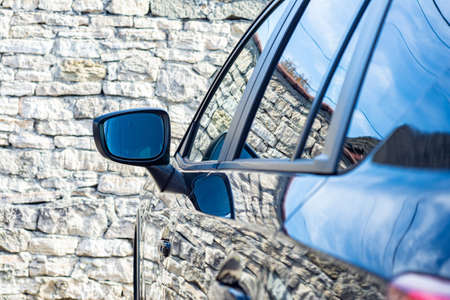 Door car - detail of a luxury car. Mirror on the car in the morning. Background.
