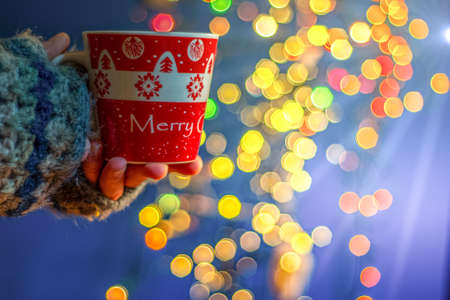 Woman holding mug with mulled wine or hot chocolate at christmas market.の写真素材