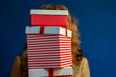 woman holding pile of christmas present boxes