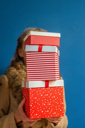 woman holding pile of christmas present boxesの写真素材