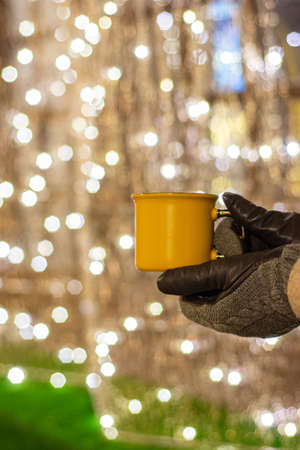 Woman holding mug with mulled wine or hot chocolate at christmas market.の写真素材