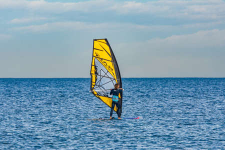 "Port Saplaya, Spain - 12.10.2021: Windsurfing. Surfer exercising in calm sea or ocean."のeditorial素材