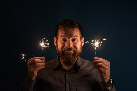 Caucasian man playing with sparklers celebration and festive party conceptの写真素材