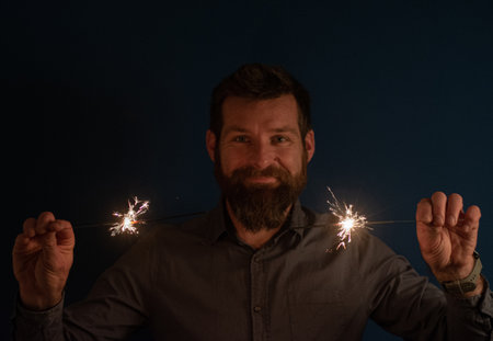 Caucasian man playing with sparklers celebration and festive party conceptの写真素材
