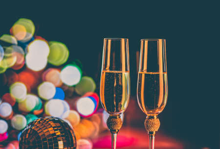 Champagne glasses on sparkling background. Two champagne glasses ready to bring in the New Year.の写真素材
