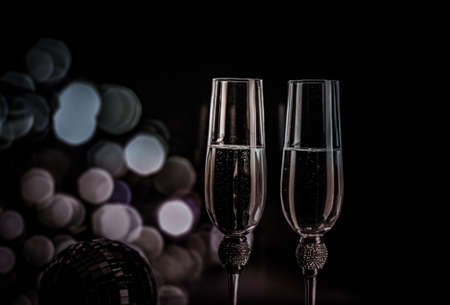 Champagne glasses on sparkling background. Two champagne glasses ready to bring in the New Year.の写真素材