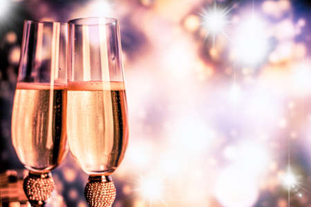 Champagne glasses on sparkling background. Two champagne glasses ready to bring in the New Year.の写真素材