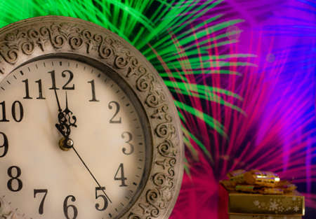 new year clock before midnight. toasting with champagne glasses against holiday lights. new year celebration conceptの写真素材