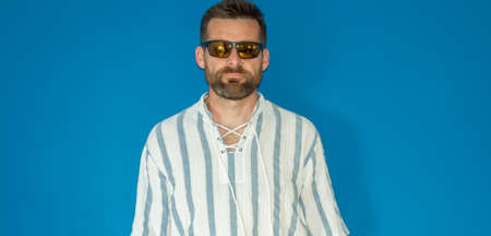 Portrait Of Young Man Standing Blue Background With Sunglasses