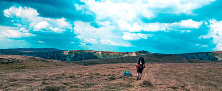 Single hike in the mountains. View of the highlands with a walking man.の写真素材