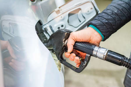 gas station putting gasoline into car oil price