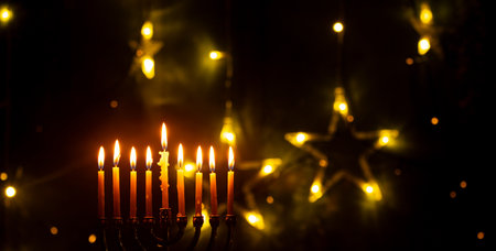 A glowing Hanukkah menorah with burning candles surrounded by soft warm lights. Perfect for celebrating the Jewish Festival of Lights, symbolizing hope, warmth, and tradition. Ideal for holiday greeting cards, blogs, and seasonal designs.の写真素材
