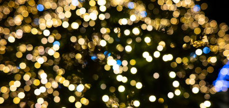 Abstract golden bokeh light tunnel with radiating, defocused festive lights. A warm, glowing background perfect for holiday, Christmas, celebration, and decorative design projects.の写真素材