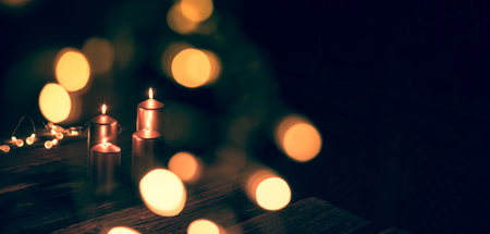 Elegant bronze candles glow warmly against a dark background, surrounded by soft golden bokeh lights...
