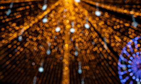 Abstract golden bokeh light tunnel with radiating, defocused festive lights. A warm, glowing background perfect for holiday, Christmas, celebration, and decorative design projects.の写真素材