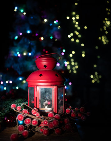 Red Lantern with Candle and Christmas Decorations in Front of a Lit Tree