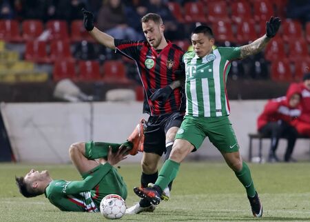 BUDAPEST, HUNGARY - FEBRUARY 27, 2016: Duel between Marton Eppel of Honved (m) and Cristian Ramirez (r) of Ferencvaros next to injured Adam Pinter during Budapest Honved - Ferencvaros OTP Bank League football match at Bozsik Stadium.のeditorial素材