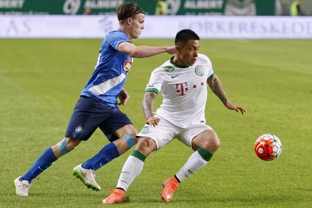 BUDAPEST, HUNGARY - APRIL 16, 2016: Cristian Ramirez of Ferencvaros (r) duels for the ball with Daniel Gera of MTK Budapest during Ferencvaros - MTK Budapest OTP Bank League football match at Groupama Arena.のeditorial素材