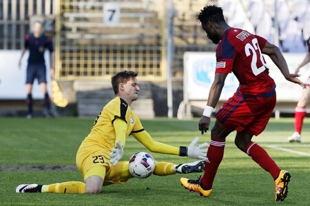 BUDAPEST, HUNGARY - APRIL 30, 2016: Goalkeeper David Banai of Ujpest (l) saves a shot from Stopira of Videoton during Ujpest - Videoton OTP Bank League football match at Szusza Stadium.のeditorial素材