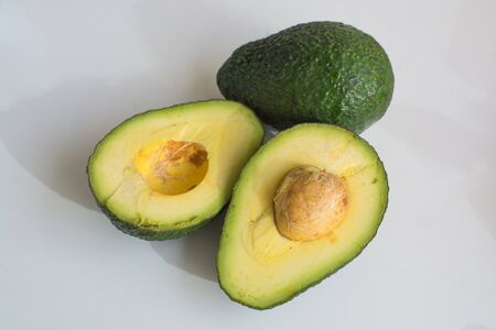 Fress hass green avocado sliced in half on light background