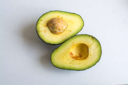 Fress hass green avocado sliced in half on light background