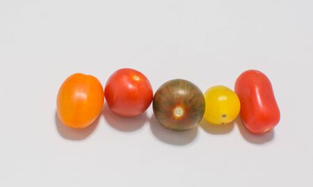 Different varieties of cherry cocktail tomatoes on a white backgroundの写真素材