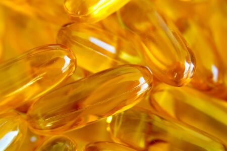 extreme closeup of bright yellow fish oil omega 3 capsulesの写真素材