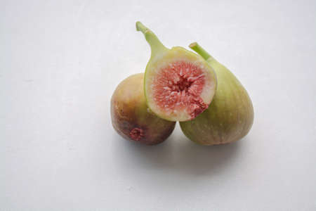 Green fresh fig fruit whole and cross section on a light background