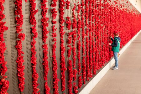 Canberra, ACT, Australia - Sept 1 2018: poppy decoration next to the wall of fallen soldiers at the Australian War Memorial - Lest we forget, Remembrance of war losses.のeditorial素材