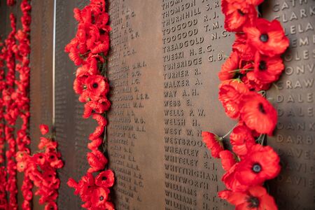 Canberra, ACT, Australia - Sept 1 2018: poppy decoration next to the wall of fallen soldiers at the Australian War Memorial - Lest we forget, Remembrance of war losses.のeditorial素材