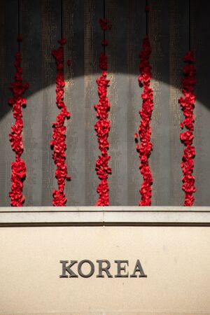 Canberra, ACT, Australia - Sept 1 2018: poppy decoration next to the wall of fallen soldiers at the Australian War Memorial - Lest we forget, Remembrance of war losses.のeditorial素材