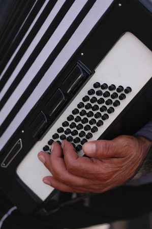 The hand of a musician playing the accordions outdoorsの写真素材