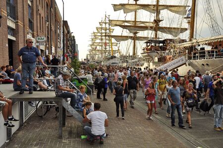 Veemkade, Amsterdam, the Netherlands - August 21, 2015: Spectators walking on the pavement next to the tall ships docked at the Ijhaven port of Amsterdam, at the time of the SAIL www.sail.nl, an international public nautical event held once in every 5 yeaのeditorial素材