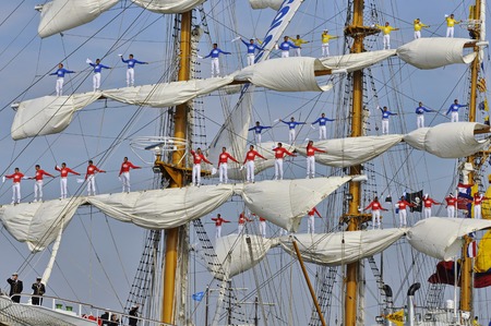 Port Amsterdam, Amsterdam, the Netherlands - August 23, 2015: Sailors of the ARC Gloria tall ship Colombia standing on the masts of the ship, waving to the crowd at the closing day of the SAIL www.sail.nl, an international public nautical event held once のeditorial素材