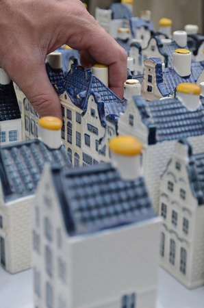 Amsterdam, Netherlands - May 21, 2016: A hand grabbing one of the KLM pottery canal houses at the flee market at the Northern Market (Noordermarkt), in the Jordaan district.のeditorial素材