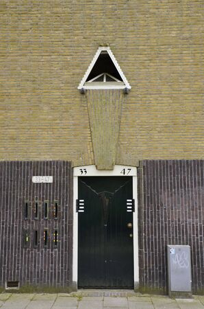 Amsterdam, Netherlands - May 21, 2016: Single yellow brick residential building entrance, in Amsterdam School architecture style, in the Spaarndammerbuurt district.のeditorial素材