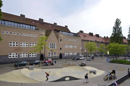 Amsterdam, Netherlands - May 21, 2016: View of an Amsterdam School bulding with skate boarders in the foreground,  on the Zaandammerplein, in the Spaarndammerbuurt.のeditorial素材