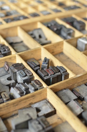 Side view of metallic letters in a wooden box, used for letterpress printing on a manual print machineの写真素材