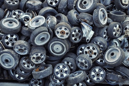 Small plastic wheels used for shopping carts and hospital beds, piled up at a dumpの写真素材