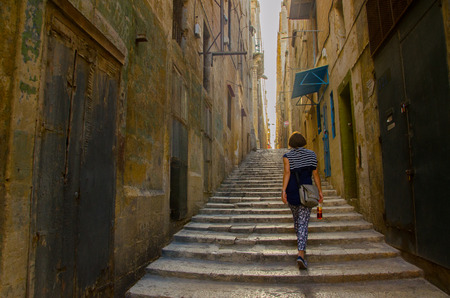 Valletta,MALTA -CIRCA OCTOBER, 2015- A woman walks through the street of Valletta.の写真素材