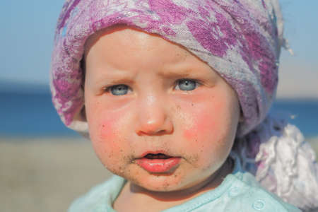Portrait of an adorable little girl playing on the beachの写真素材