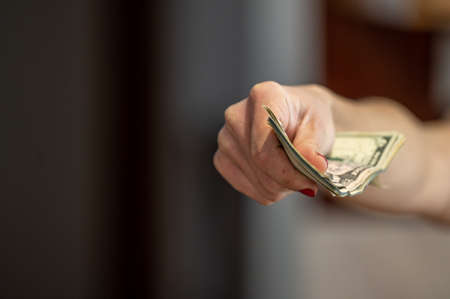 Closeup of woman hand giving money.の写真素材