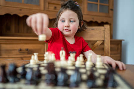 A smart little girl playing chess.の写真素材
