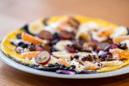 Delicious breakfast idea. Omelette with fruit, yogurt, and chocolate.の写真素材