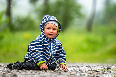 One year old baby playing in the rain.の写真素材