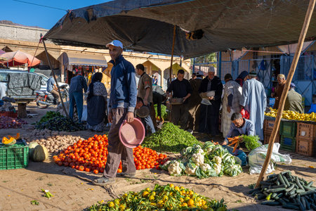 Ouzioua, Taroudant Province, Morocco - November 29, 2022: People trading at a traditional Arabian street market in the small town of Ouzioua in the Atlas Mountains.のeditorial素材